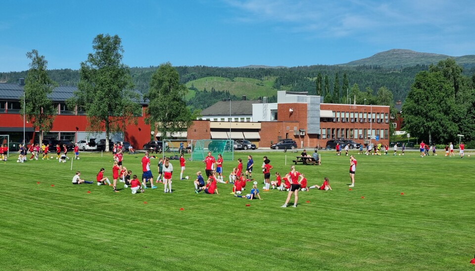 Spillere som hviler i sola på fotballbanen.