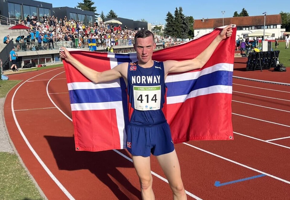 Magnus Øyen. Arkivfoto fra EYOF i 2023, der han tok sølv på 3000m. En ung mann i løperdrakt på en friidrettsstadion, med et norsk flagg bak ryggen.