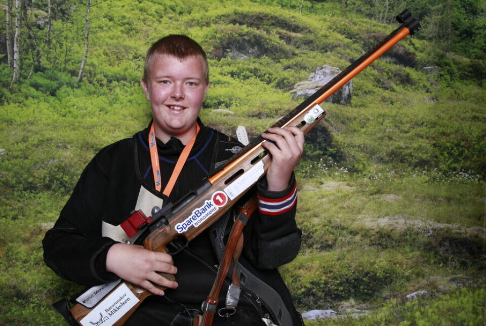 En ung gutt oppstilt i fullt skytterutstyr med rifle.