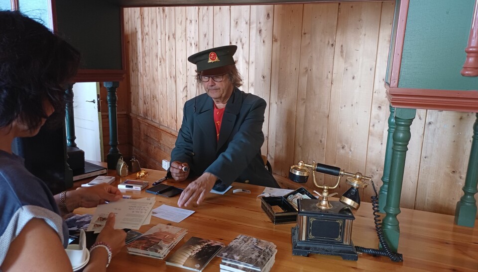 En mann er kledd i en gammel postmann uniform