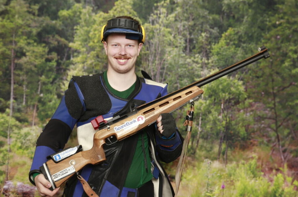En mannlig skytter oppstilt i fullt skytterutsyr med rifle.