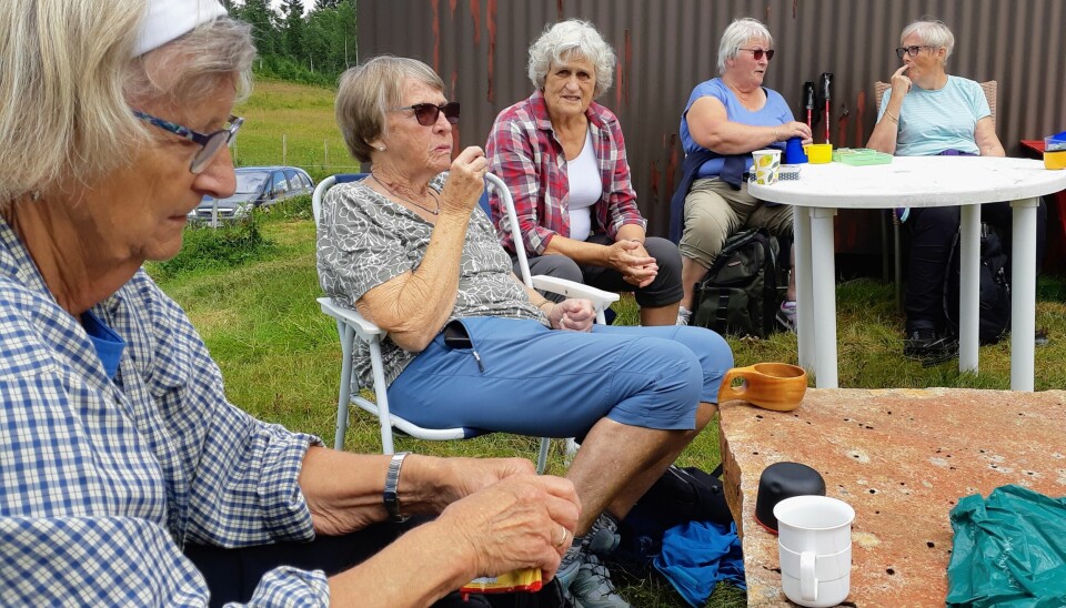 Eldre mennesker sitter og spiser matpakke utendørs