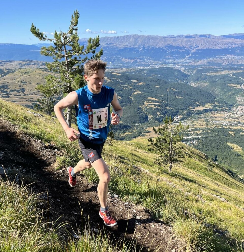 En ung gutt med startnummer som løper på en smal sti i ei fjellside.