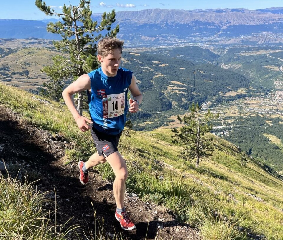 Aron Rodal Haugen. En ung gutt med startnummer som løper på en smal sti i ei fjellside.