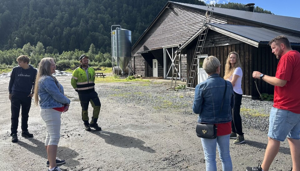 6 mennesker står i en sirkel og snakker sammen på en gårdsplass