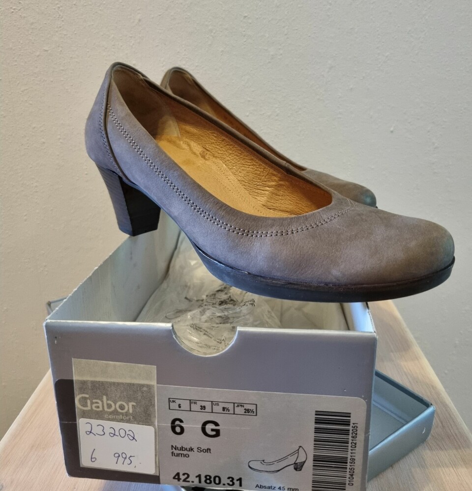 Ett par høyhelte, grå damesko i skinn står skrått på ei skoeske