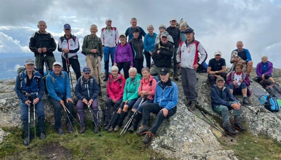 Ca 25 mennesker på et fjell. Sittende og stående.