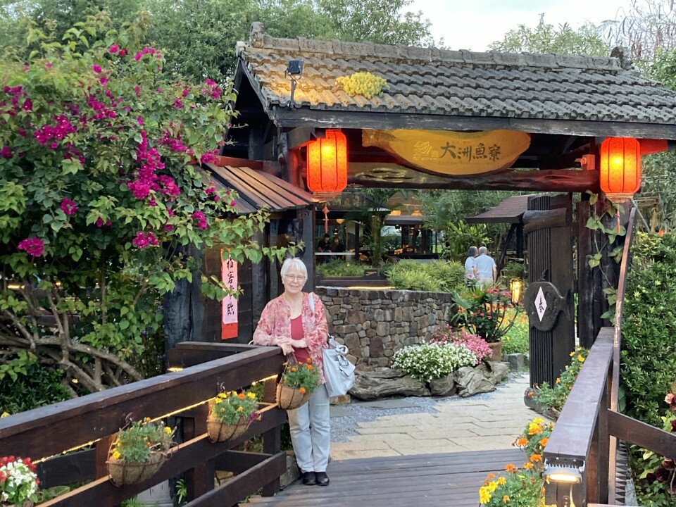 Ei dame foran inngangen til en asiatisk restaurant.
