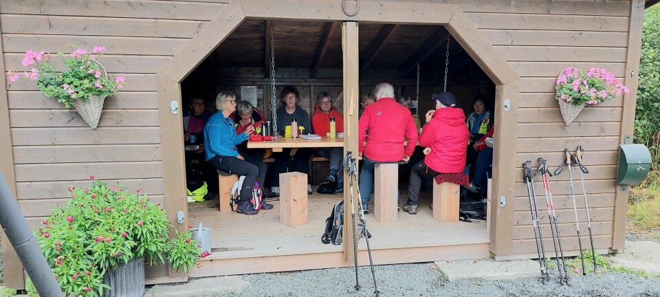 Turgåere som sitter og spiser inne i en gapahuk.