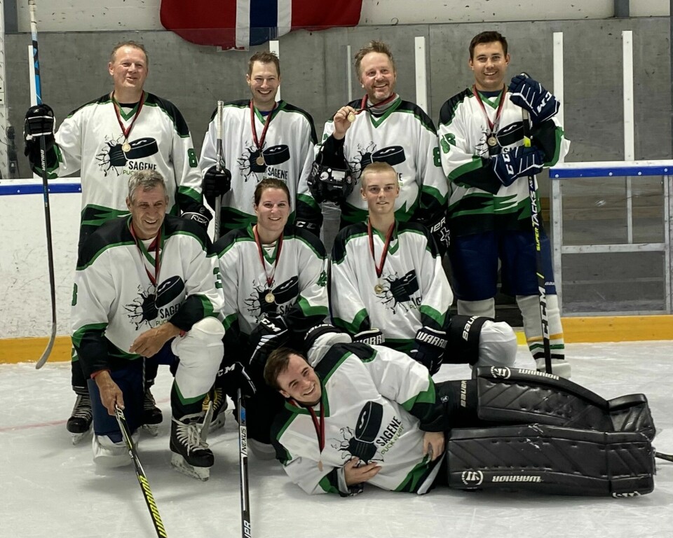 Åtte ishockeyspillere oppstilt til bilde. Fire står bak, tre sitter foran på huk og en ligger fremst.
