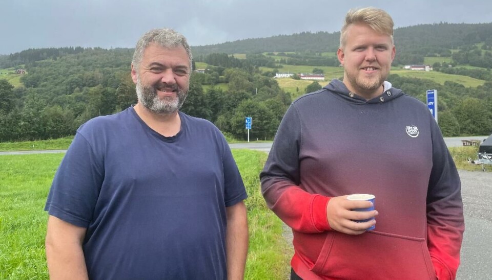 To av seks medlemmer av styret i Surnadal og Rindal snøscooterklubb. Her står leder Tore Polden sammen med Inge Skjølsvold med kommunegrensen og Nordmarka i bakgrunnen. To menn, et skilt