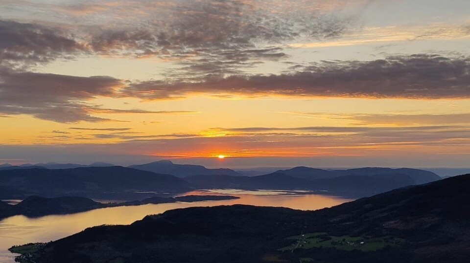 Soledgang. Flerfarget himmel over fjell og fjord.