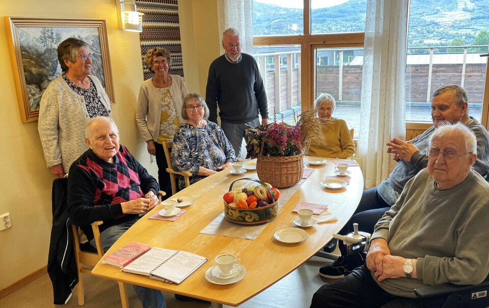 Flere pensjonister rundt et kaffebord.