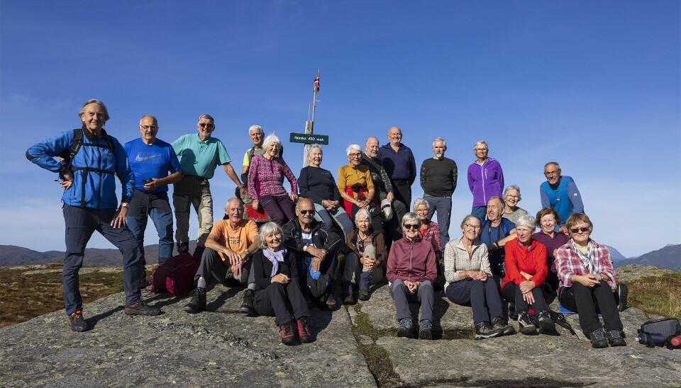 Ei gruppe turkledde pensjonister oppstilt på en fjelltopp.