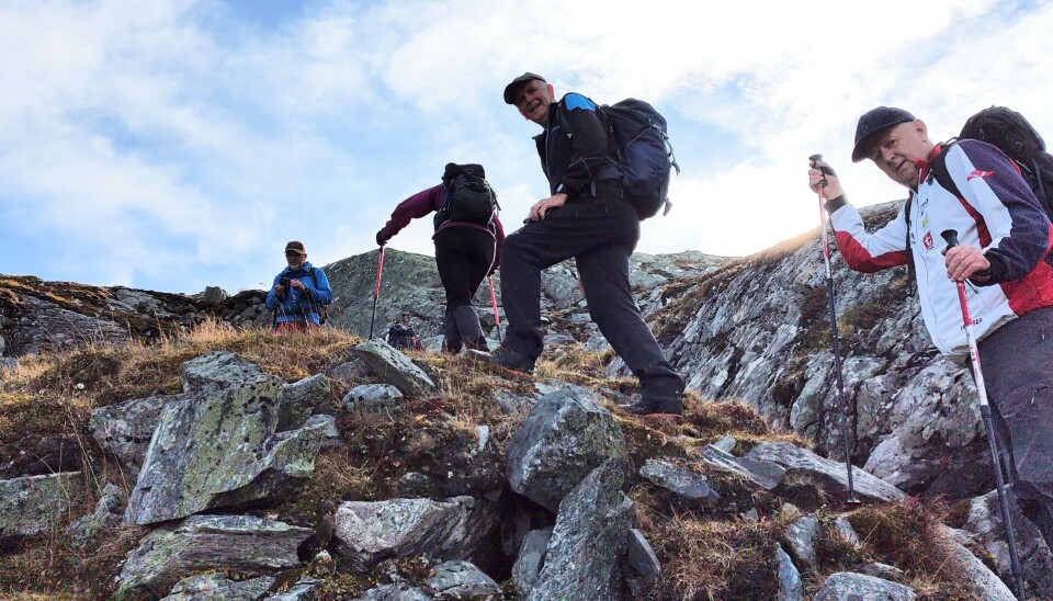 Ei gruppe turkledde folk på vei opp ei fjellside.