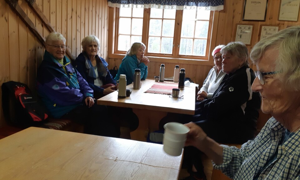 Turkledde pensjonister som drikker kaffe inne i ei hytte.