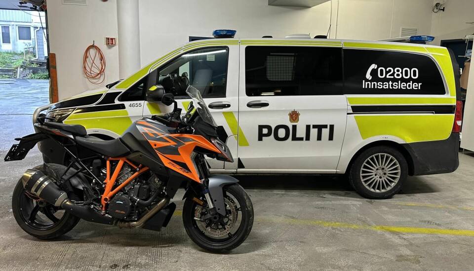 En politibil og en motorsykkel i en garasje.