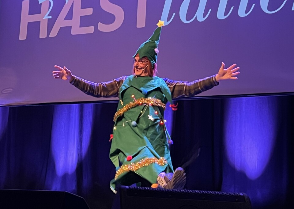 En mann kledd ut som et juletre danser bortover scenen.