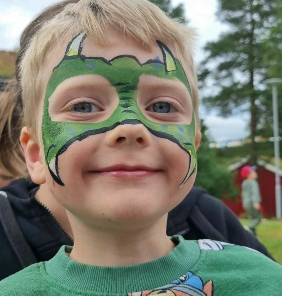 En liten gutt med grønn ansiktsmaling