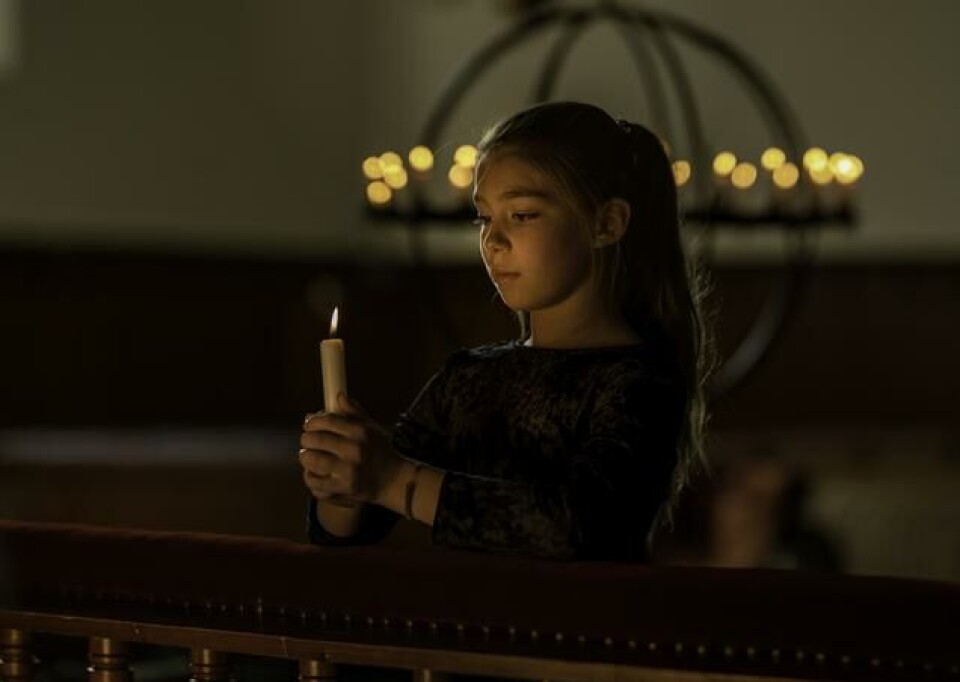Allehelgensdag – åpen kirke i Rindal Jente holder et lys i hendene.