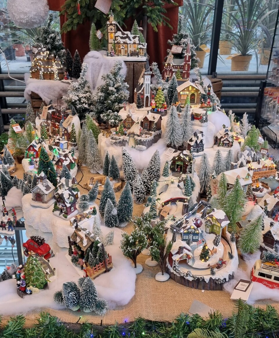 Et bord dekt med forskjellige juleting som lager en landsby