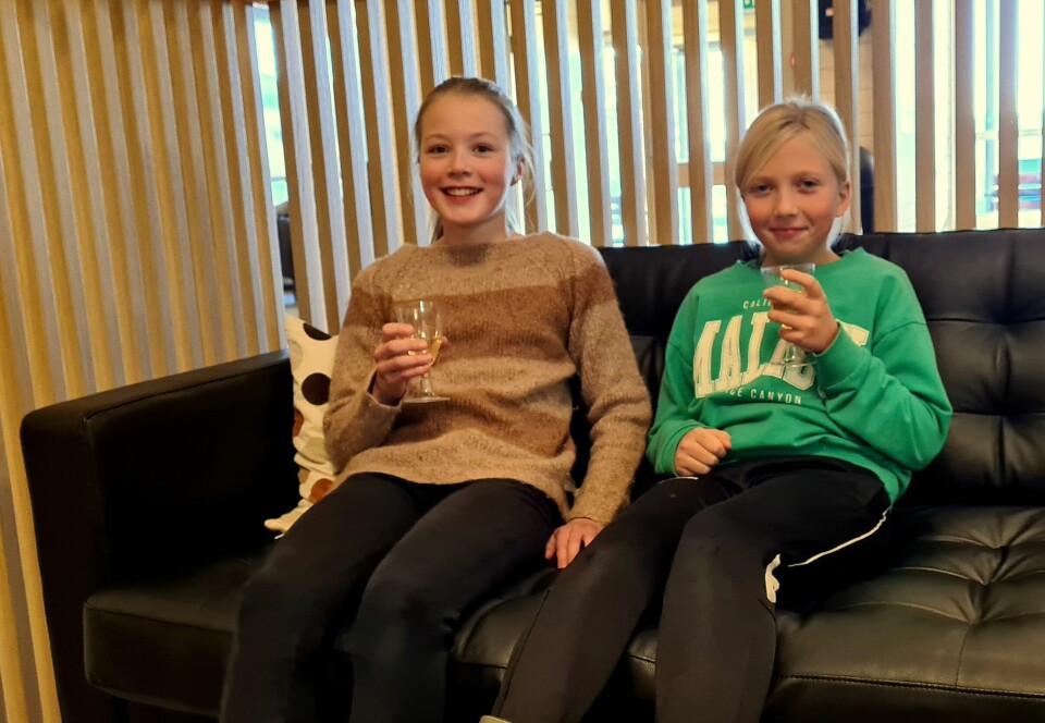To unge jenter med hvert sitt stettglass med drikke.