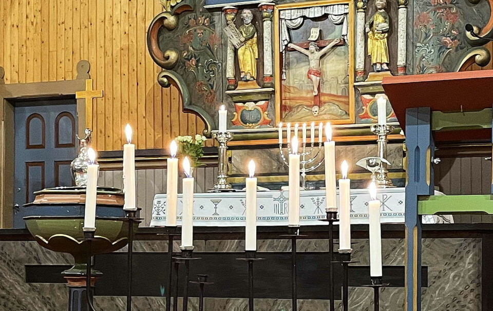 Minnelysa pregar allehelgensgudstenestene. Her i Stangvik kyrkje. Tenkte lys foran alteret i ei kirke.