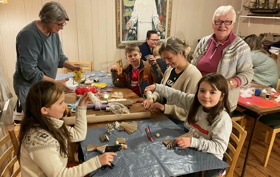 Barn og voksne rundt et bord med håndarbeid