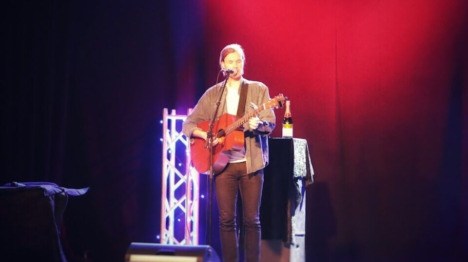 Jo Sverre En mann med gitar på en scene.