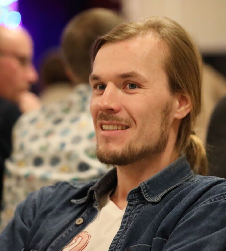 Jo Sverre En mann som sitter i en forsamling.