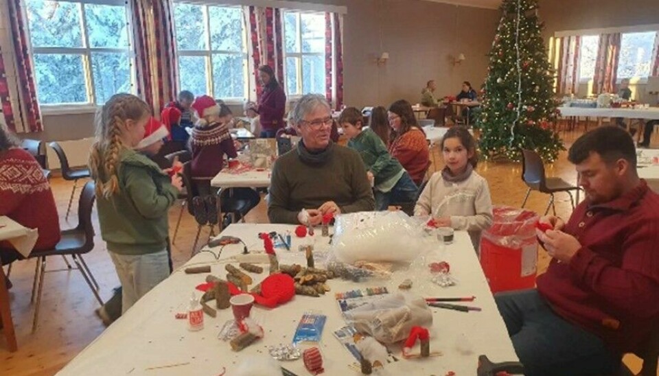 Et bord med barn og voksne rundt som lager julepynt