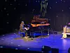 Jente speler piano på scene