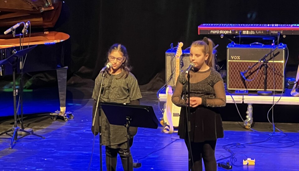 To jenter synger på scene