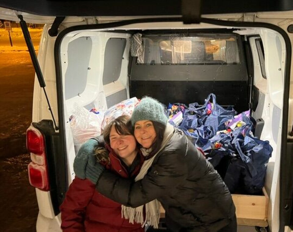 To kvinner klemmer hverandre og har bilen full av handleposer med mat