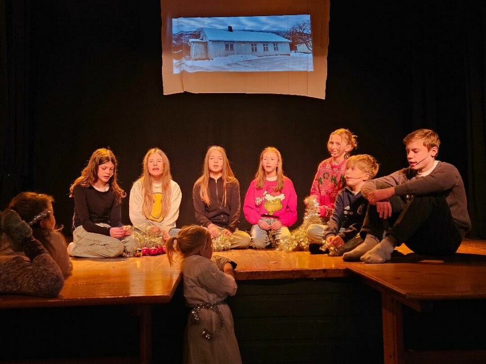 Barn 'sitter i en halvmåne' på en scene