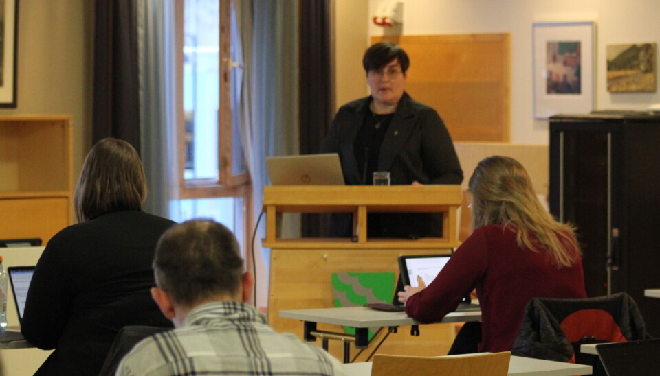 Økonomisjef Vibeke Langli la fram busjettsaka for kommuenstyret. Ei dame som står på talerstolen foran flere møtedeltakere.