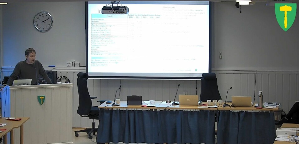 En mann som står på en talerstol i et møterom.