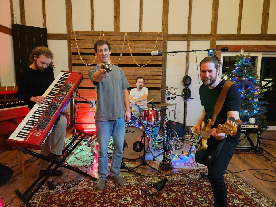 Fire musikanter med instrumenter i studio.