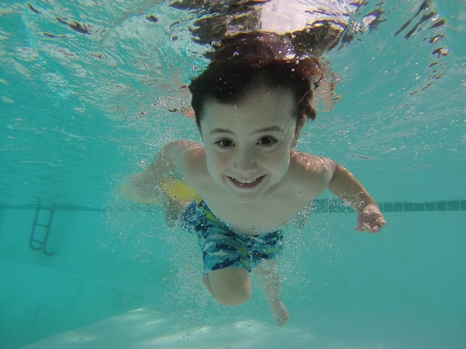 Et barn svømmer under vann