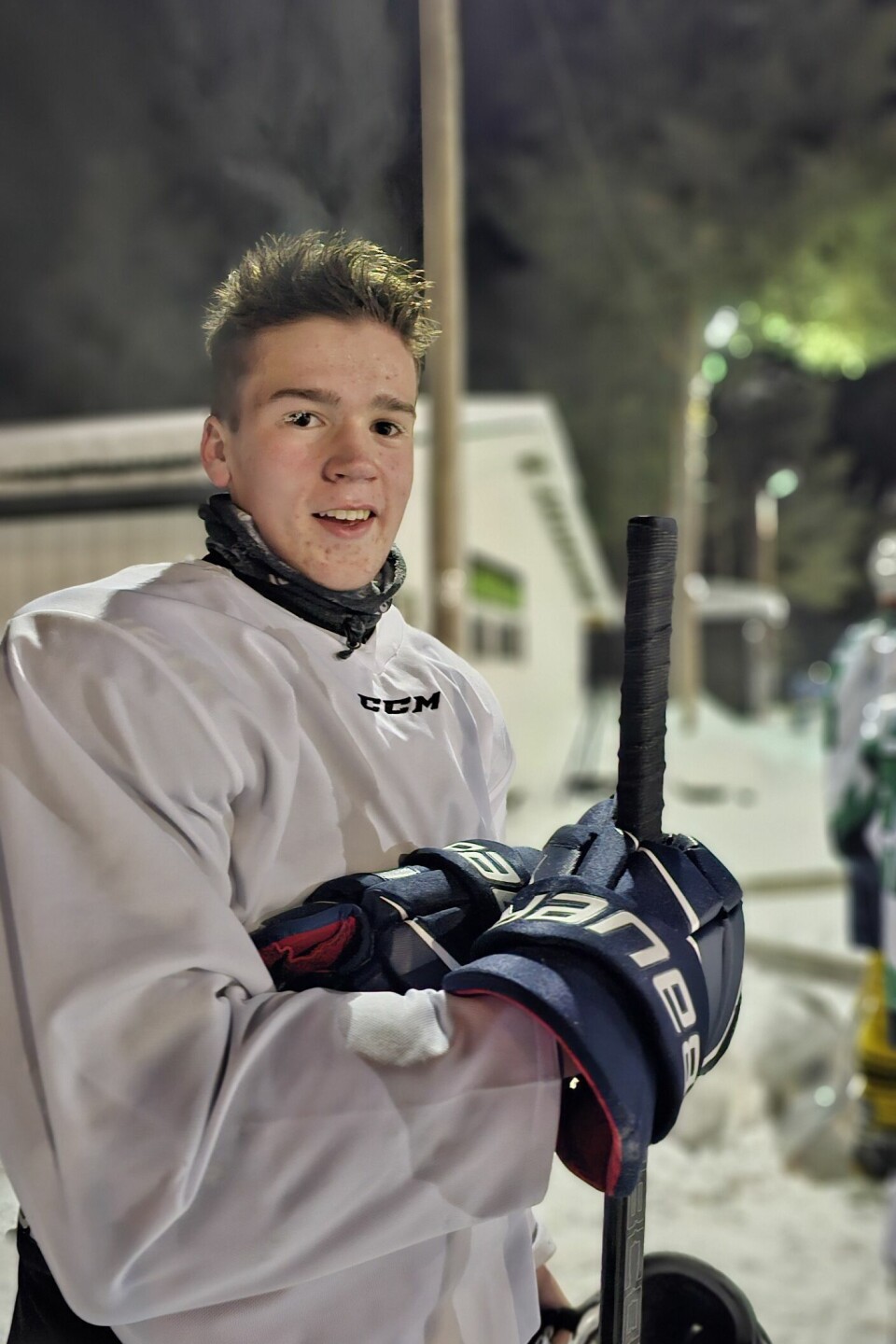 portrett av gutt i hvitkledd hockeyskjorte som har tatt av hjelmen og har rim på øyevippene