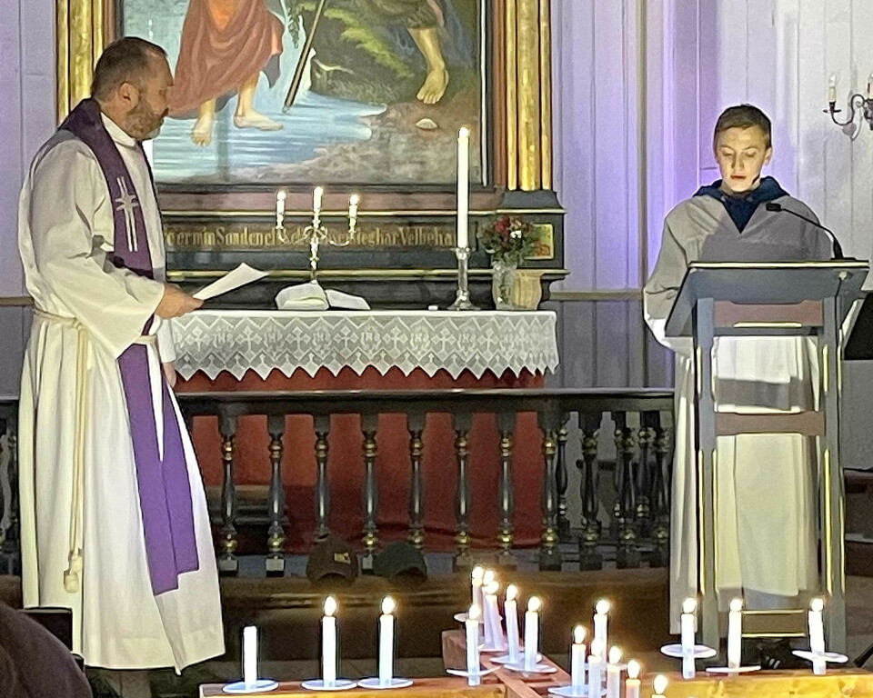 En prest og en gutt snakker i kirka