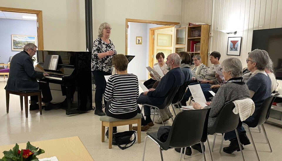 Halsa Demenskor med assistentar under øving. Turid Røen Kroknes instruerer og dirigerer. Pianist Bernt Bøe kommenterer gjerne: - Det let så reint og fint!