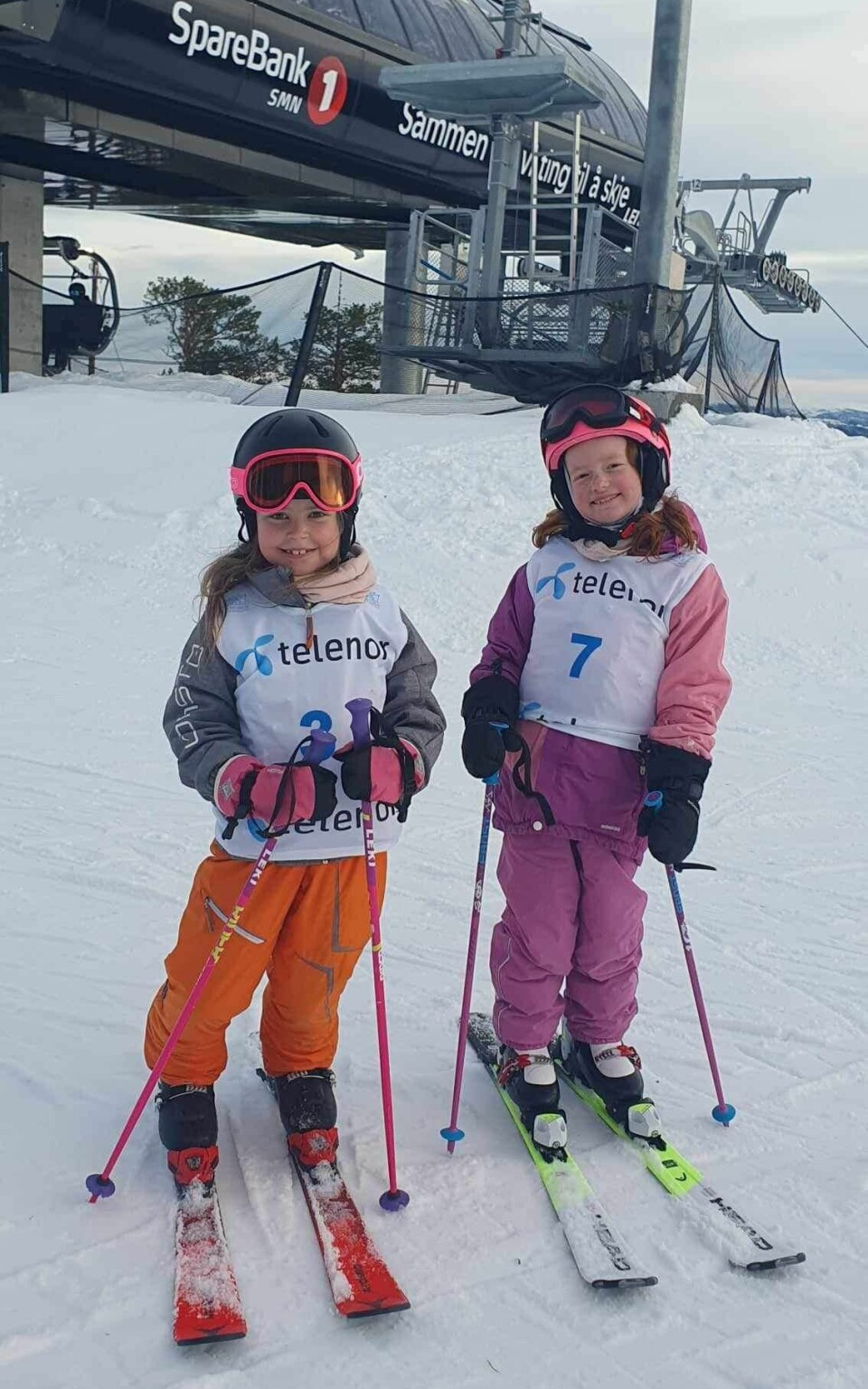 To jenter på slalåmski i et alpinanlegg.