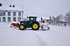 Traktor med både plog og snøfes rygger ut i Rindalsvegen for å brøte vegen bak det gamle kommunehuset på Rindal Sentrum.