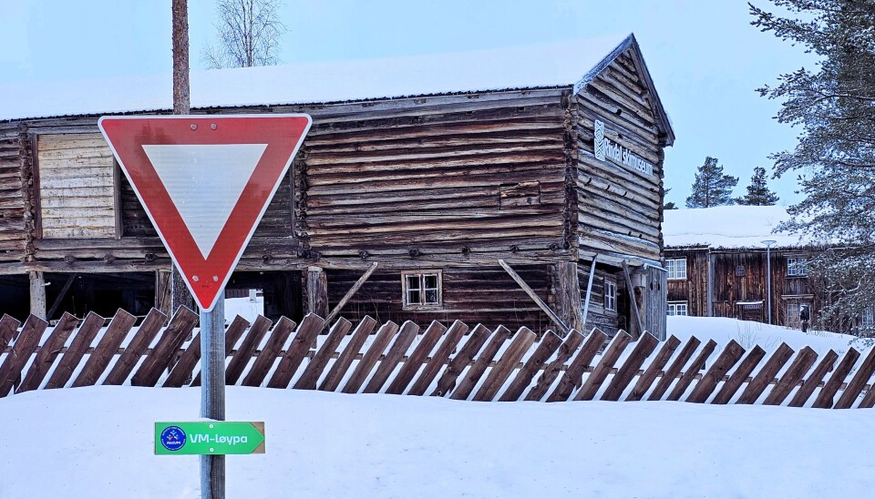 Det grønne VM-løypeskiltet er hengt på et trafikkskilt. I bakgrunnen ser du skimuseet.