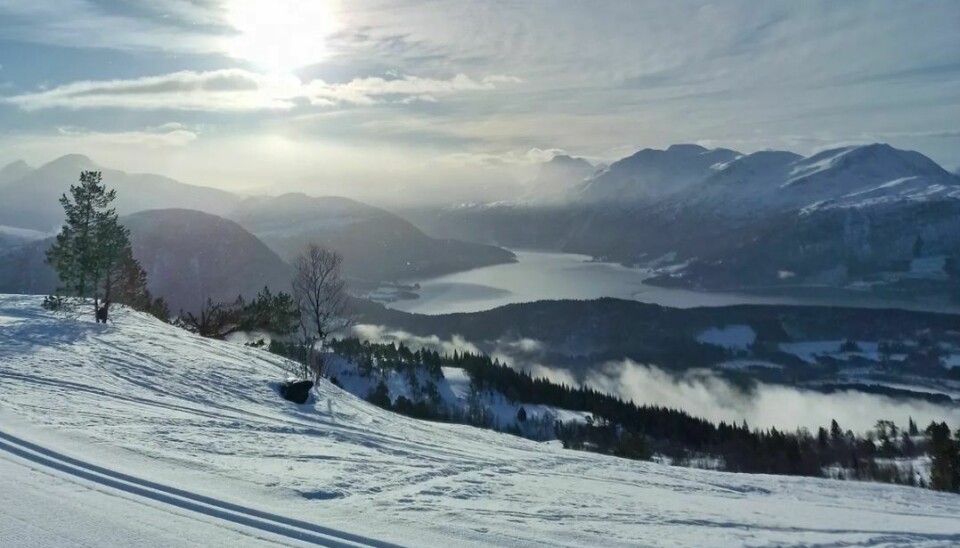 Sol over fjell og skiløyper, vinter
