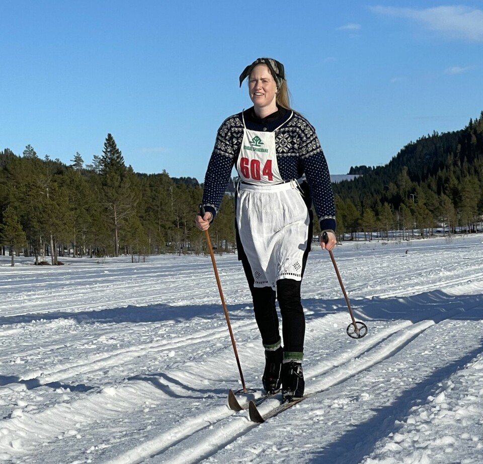 Kvinnelig skiløper med forkle og treski