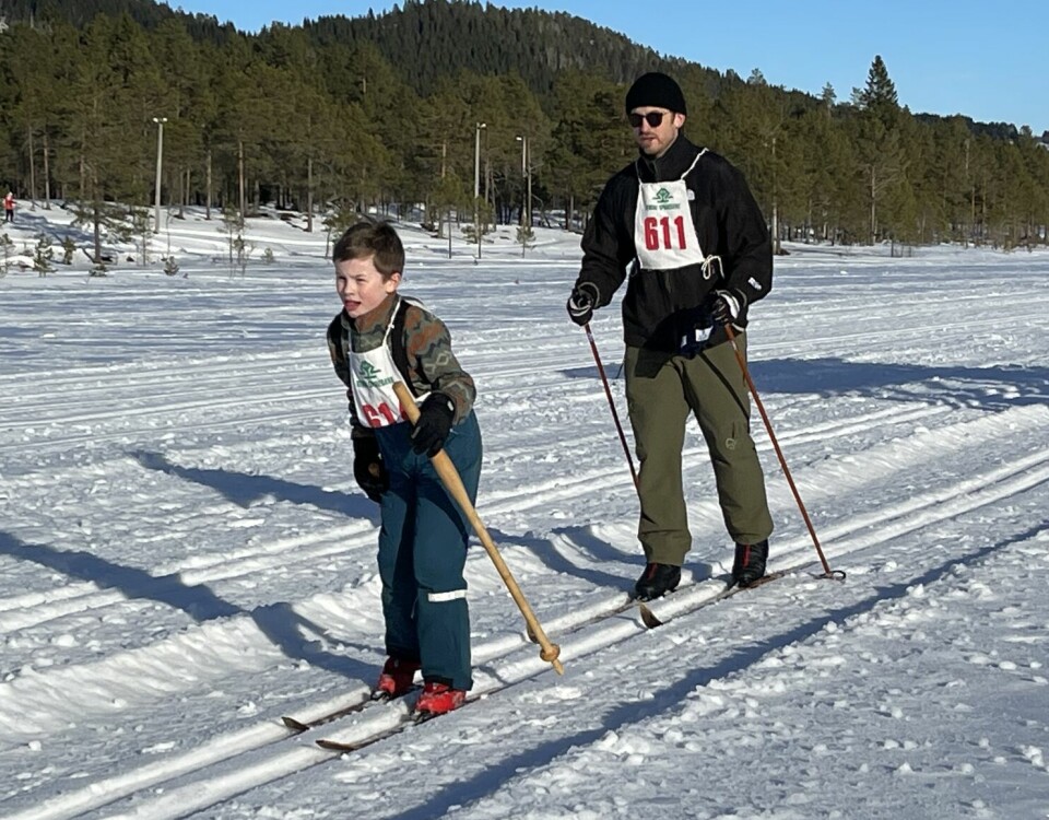 Et barn og en voksen går sammen på ski.