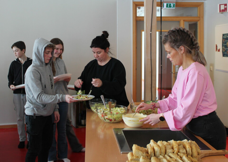 Lærere serverer mat til elevene.