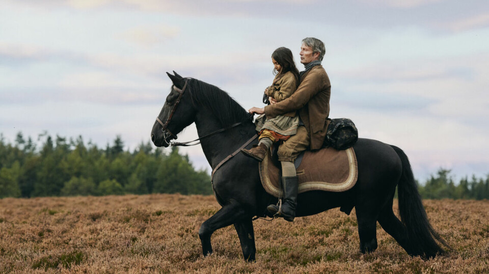 En mann og ei lita jente som rir på en hest.
